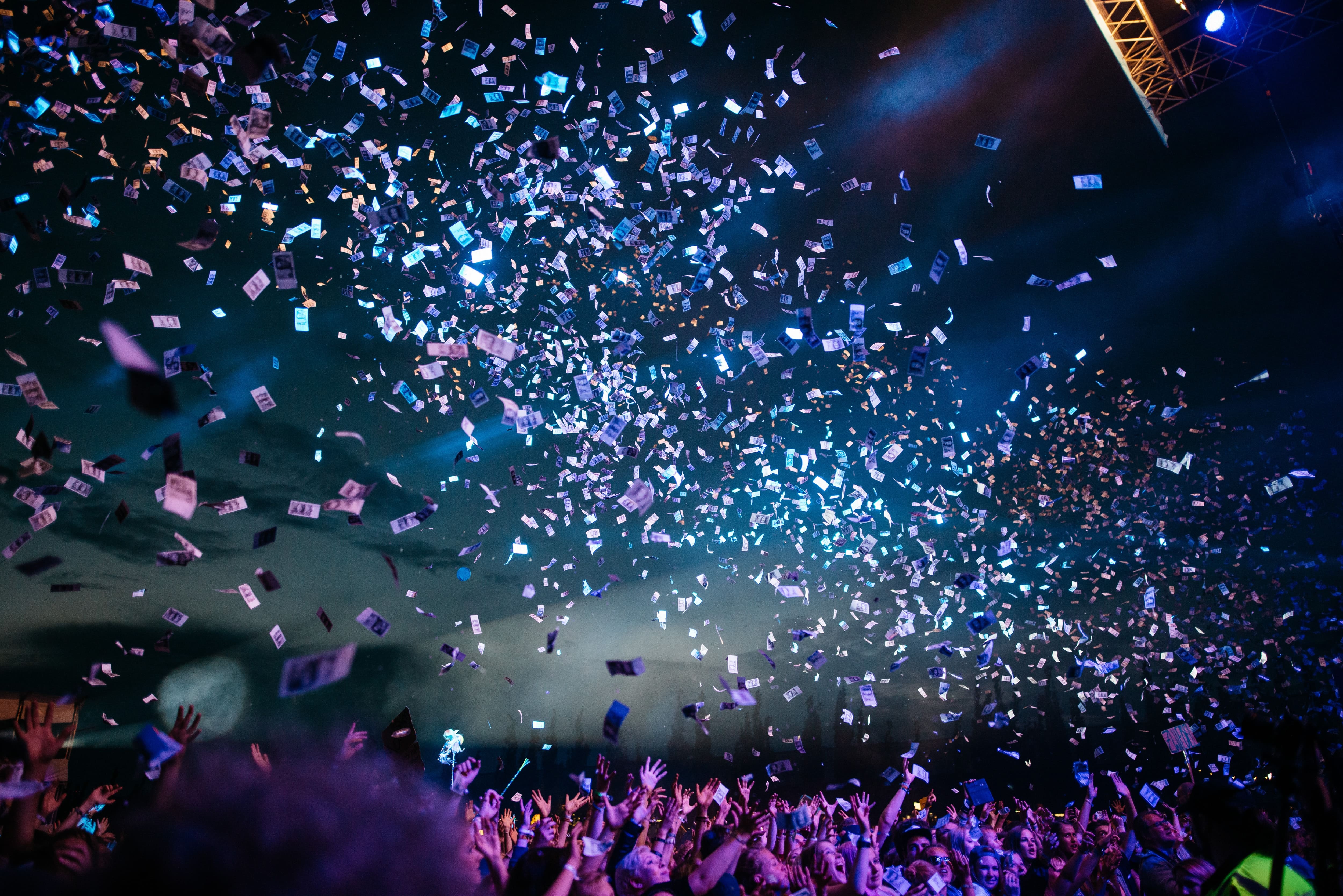 Shiny confetti being thrown onto the crowd at a music festival.